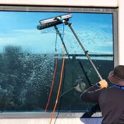 Equipe de limpeza especializada trabalhando na fachada de vidro de um edifício comercial